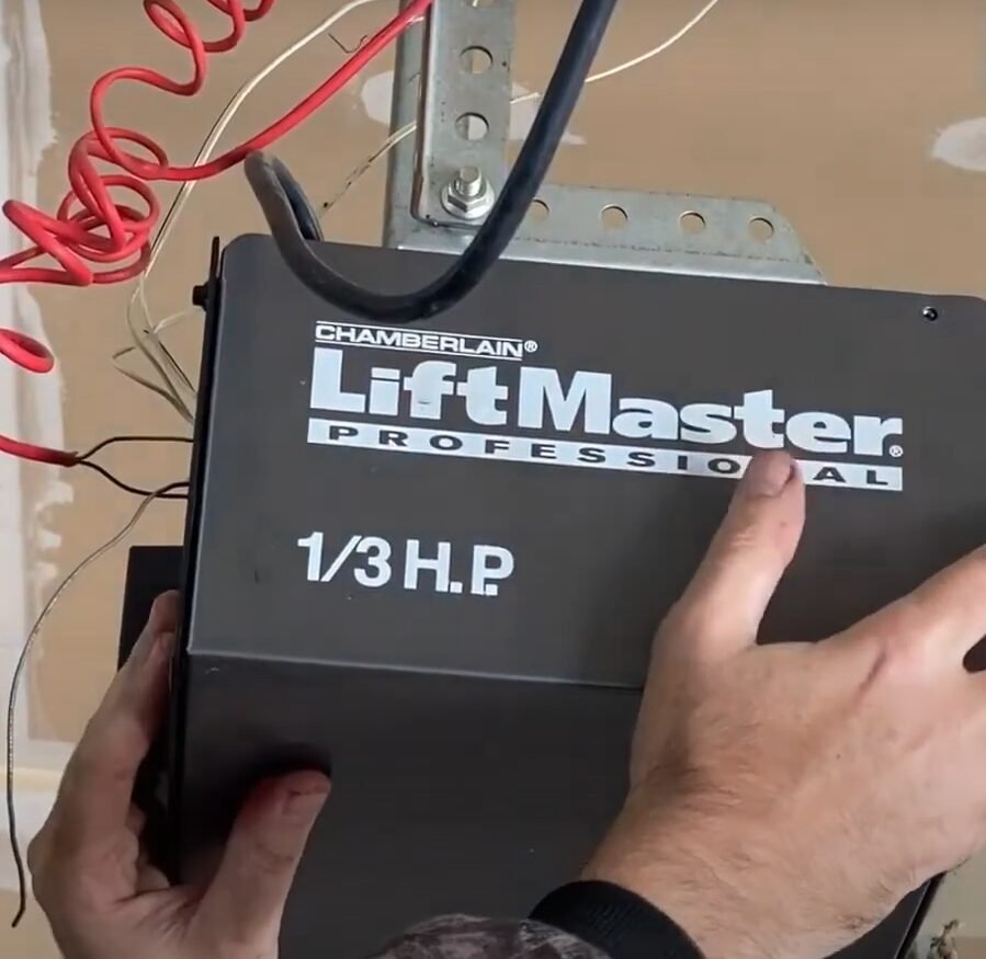 a technician wearing a uniform from Whitehall Garage Door Repair, skillfully repairing a garage door opener mechanism, showcasing the expertise in garage door opener repair services.