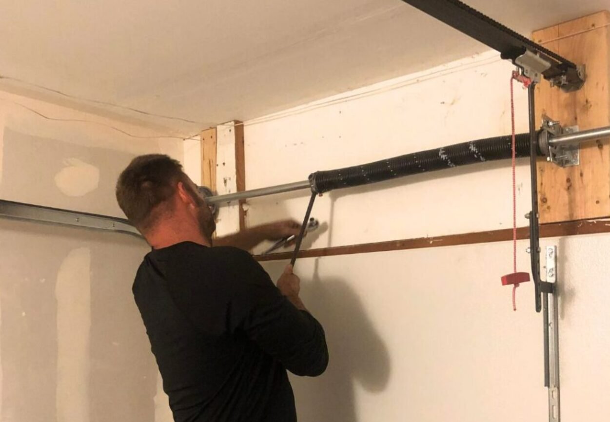 a technician from Whitehall Garage Door Repair expertly replacing a broken garage door spring in a residential setting. The focus is on the technician's hands adjusting the spring with precision tools, ensuring safe and efficient garage door spring repair.