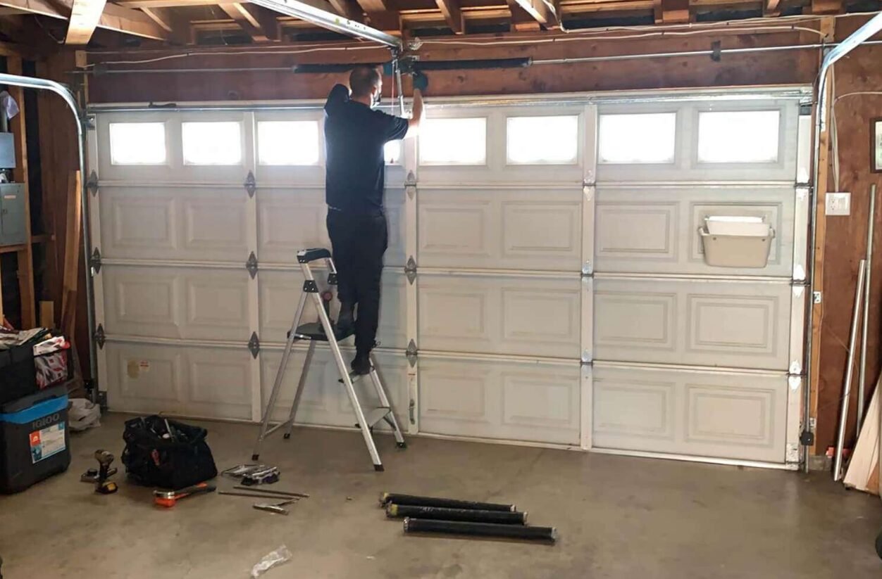 Professional technician performing garage door repair service in Whitehall